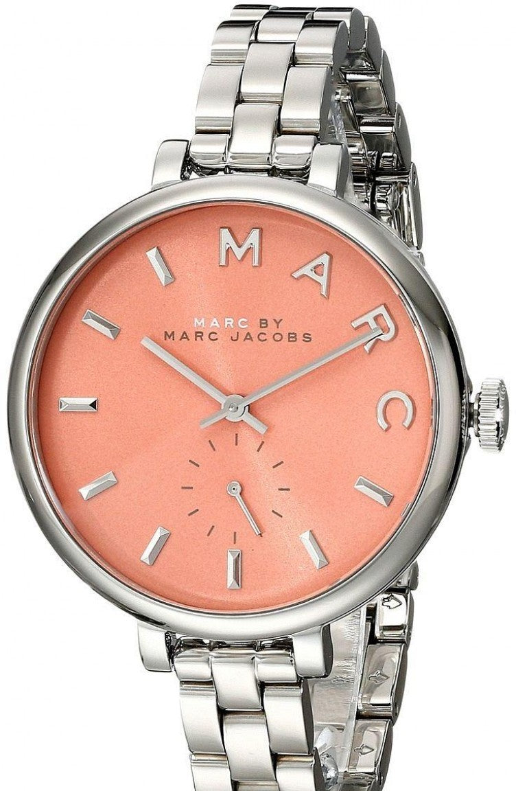 Marc Jacobs Slim Baker watch on wrist displaying orange dial and stainless steel bracelet