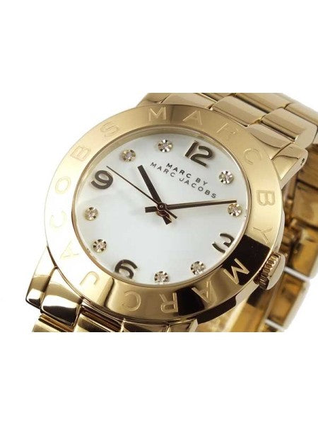 Close-up of Amy Dinky dial with white face, crystal hour markers, and gold-tone numerals