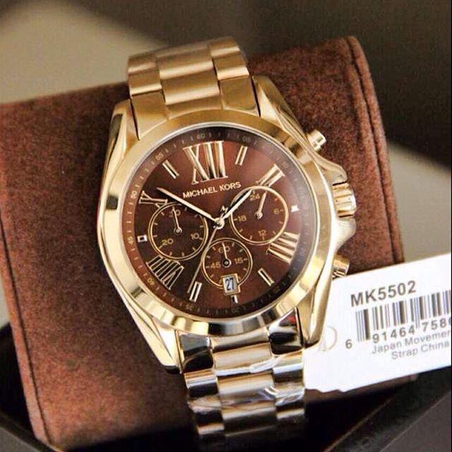 Michael Kors Bradshaw gold chronograph watch worn on wrist with packaging
