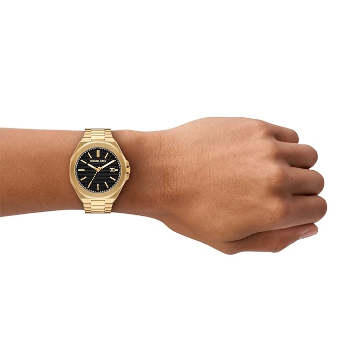 Michael Kors Callum gold watch on wrist showing black dial and gold bracelet