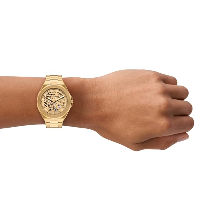 Michael Kors Callum gold watch worn on wrist showing skeleton dial and bracelet