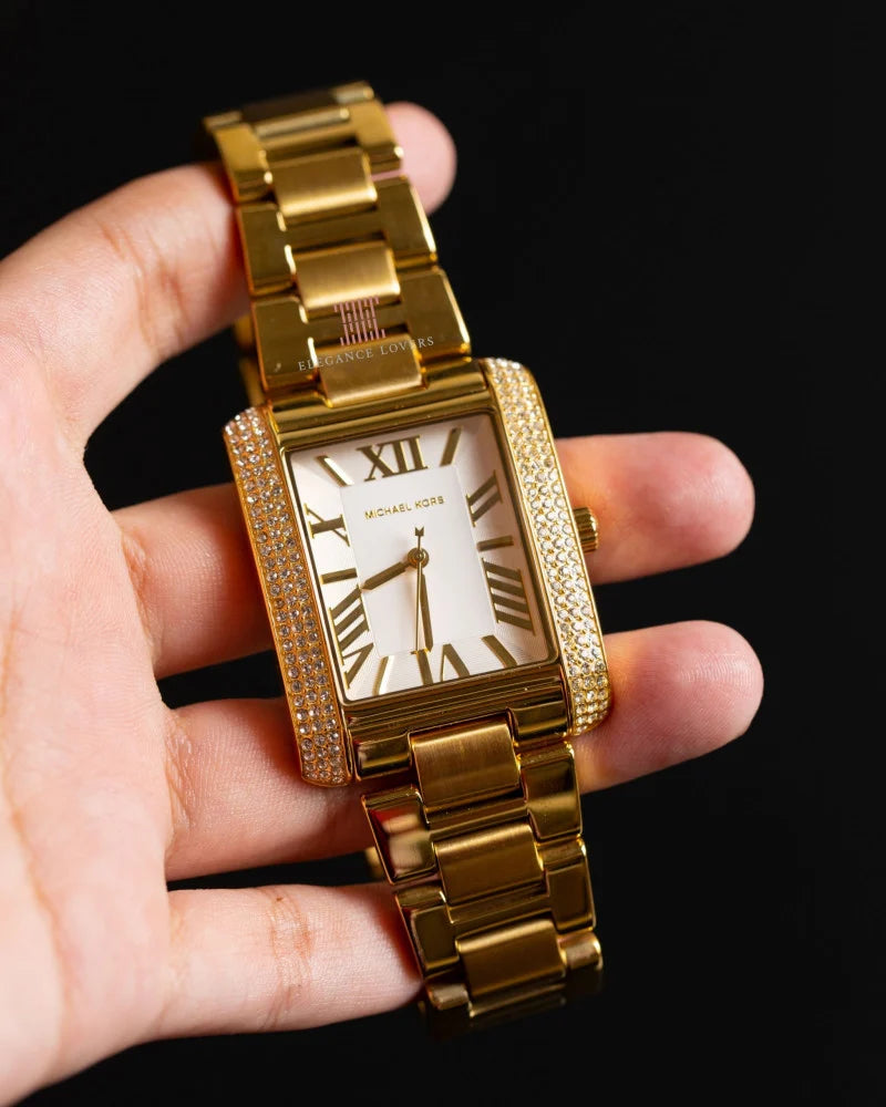 Michael Kors Camille gold-tone watch on wrist showing rectangular face and crystal-set bezel