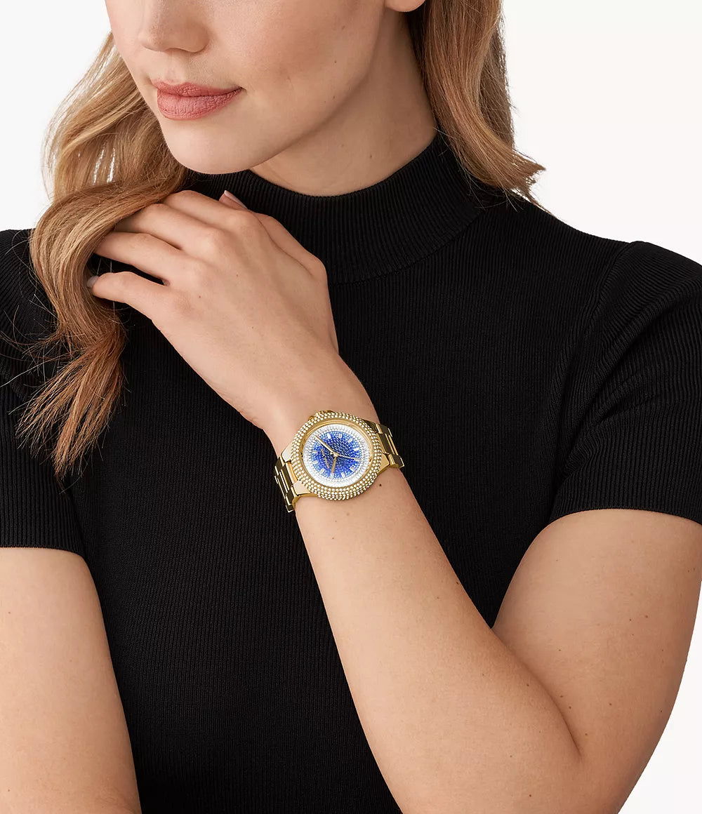 Michael Kors Camille watch worn on wrist with gold-tone bracelet and blue pavé dial