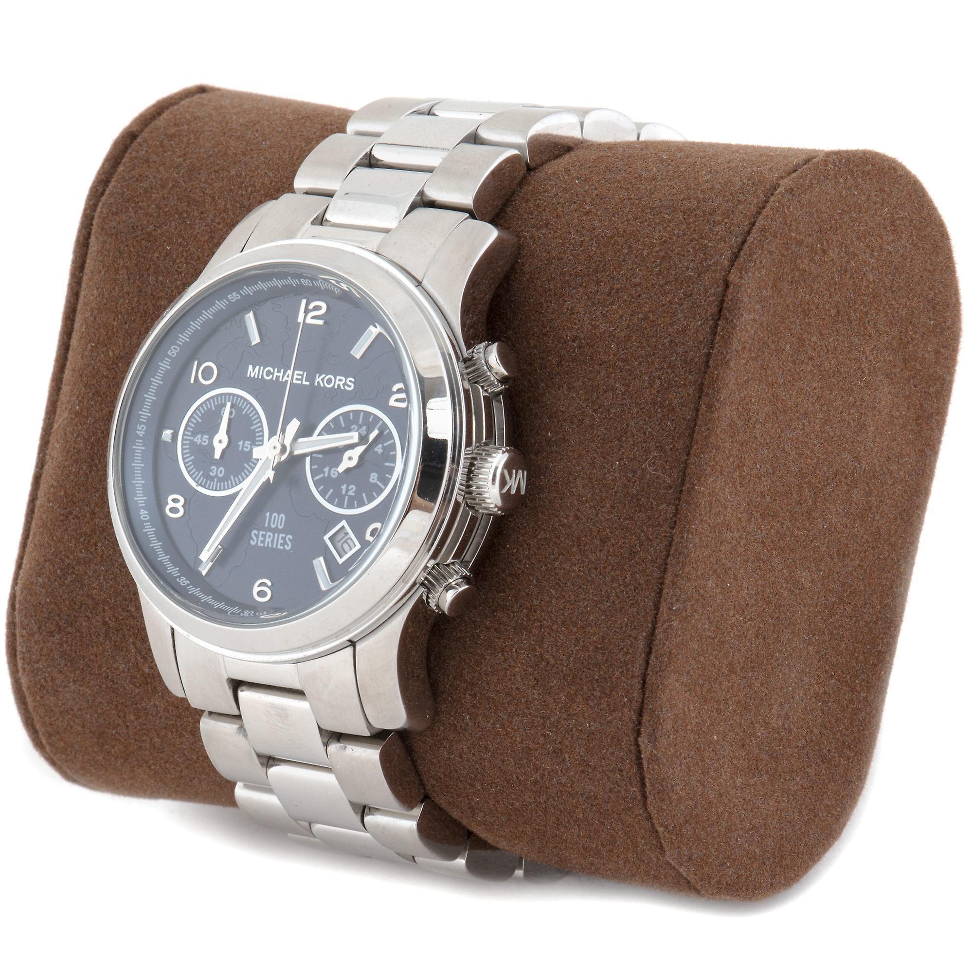 Michael Kors Hunger Stop Chronograph watch displayed on brown pillow with silver bracelet