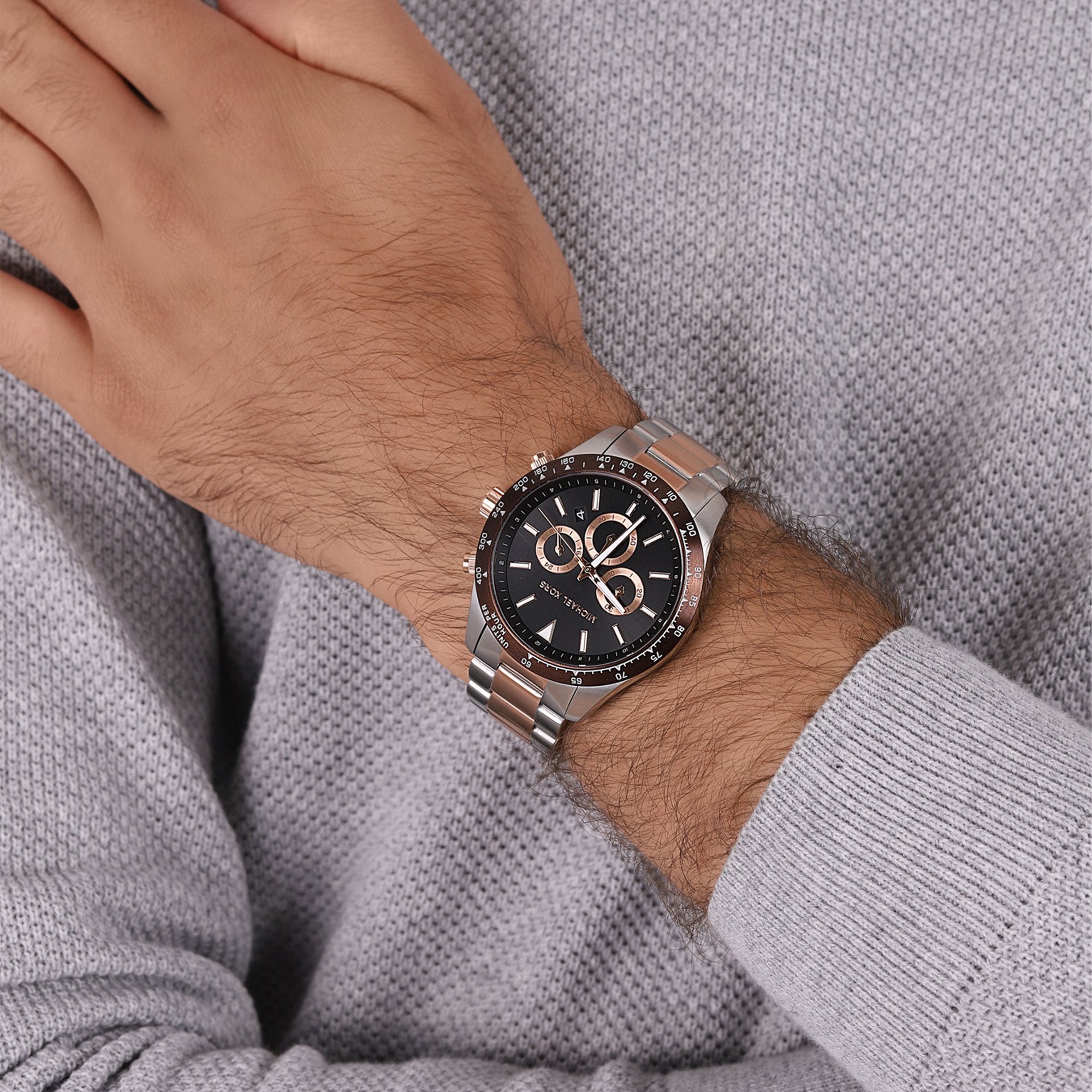 Michael Kors Layton chronograph watch worn on wrist showing black dial and two-tone bracelet