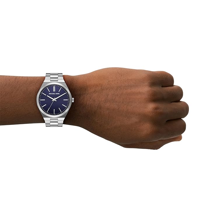 Michael Kors Lennox silver-tone watch on wrist showing navy dial and three-hand movement