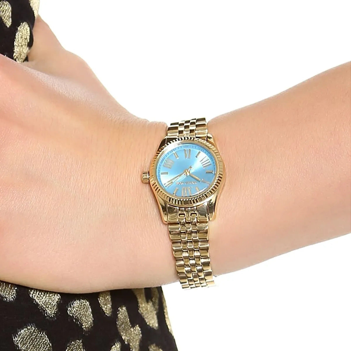 Michael Kors Petite Lexington women's watch worn on wrist showing ocean blue dial and gold bracelet