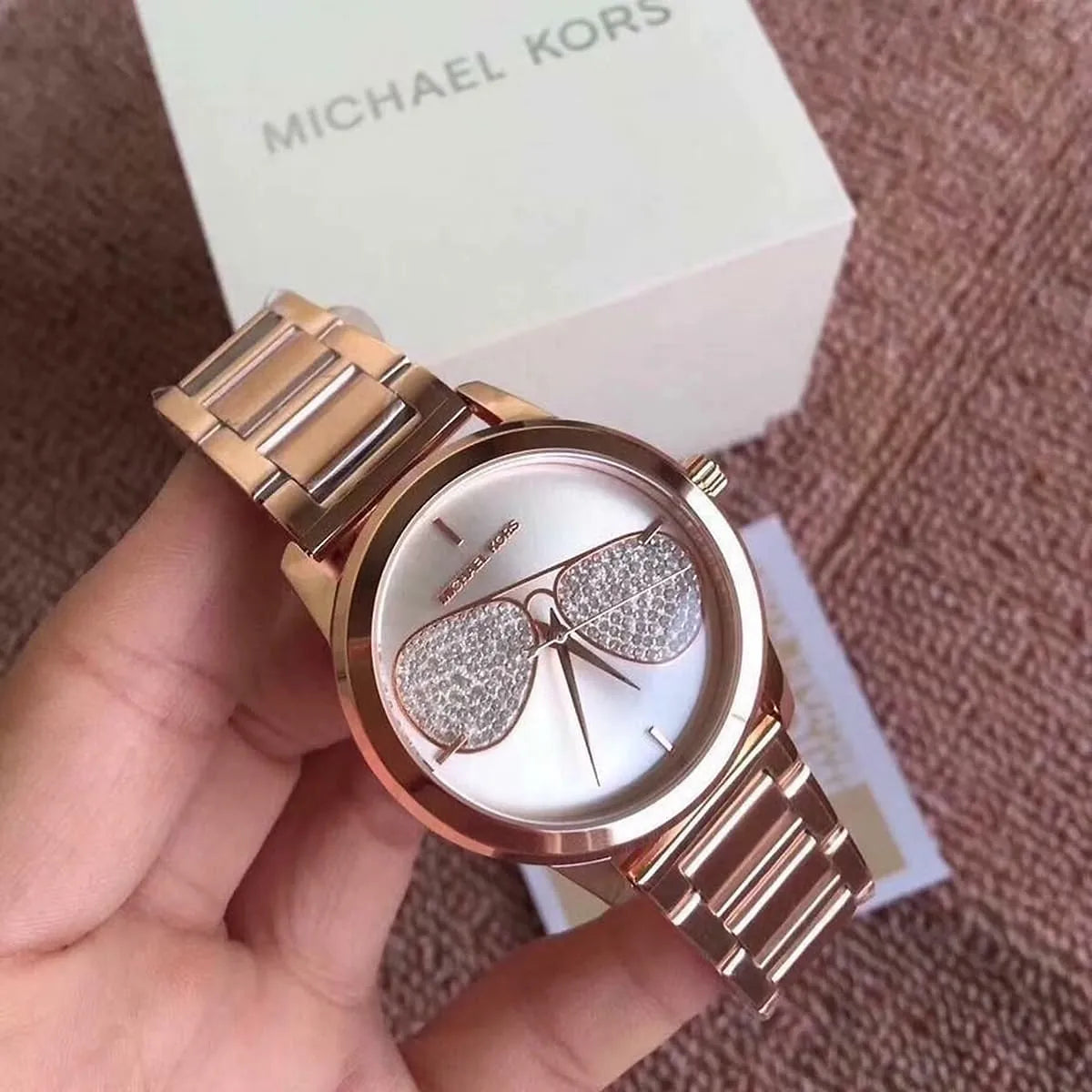 Michael Kors MK3673 held in hand with original packaging box and product label visible