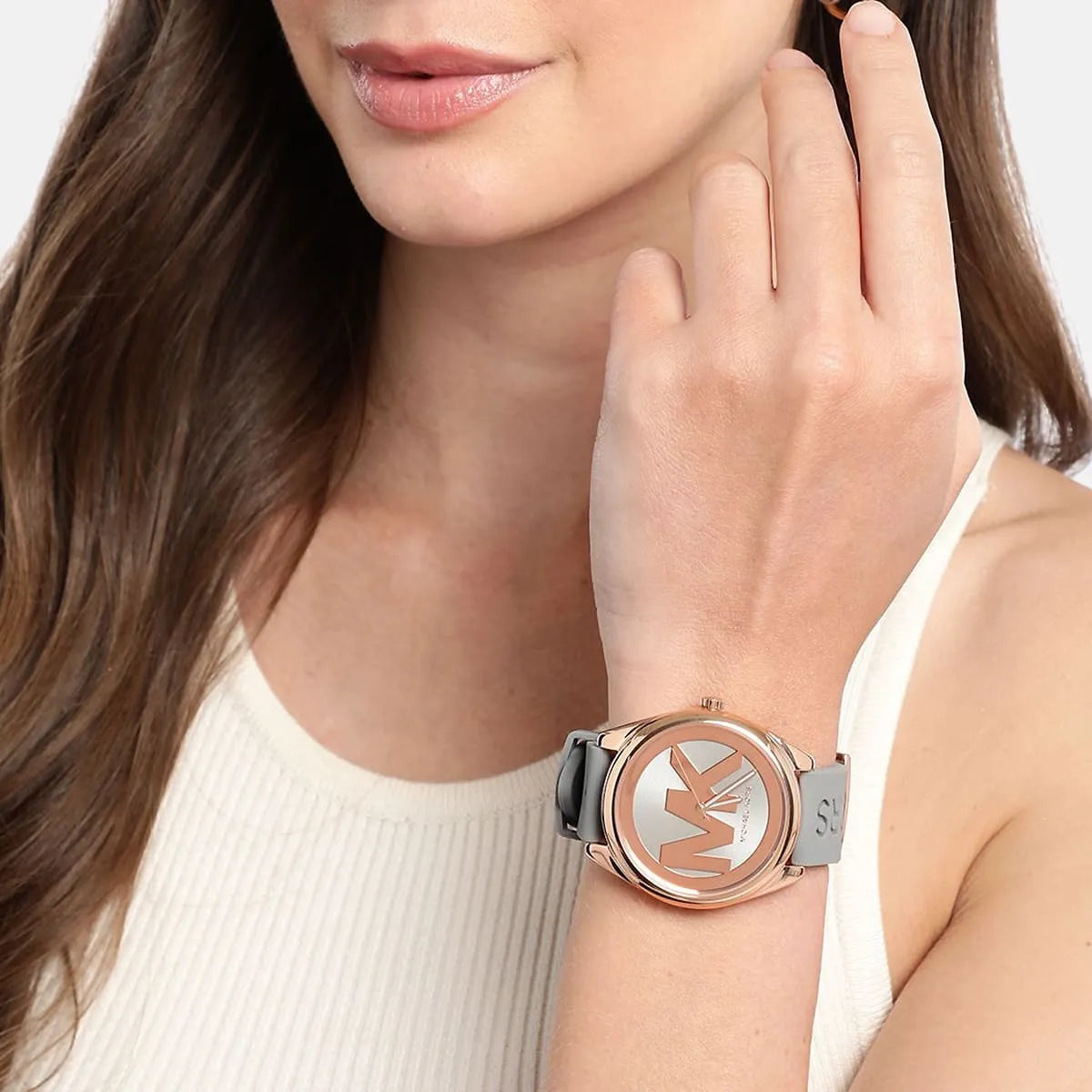 Michael Kors Janelle watch worn on wrist showing grey dial and rubber strap in natural setting