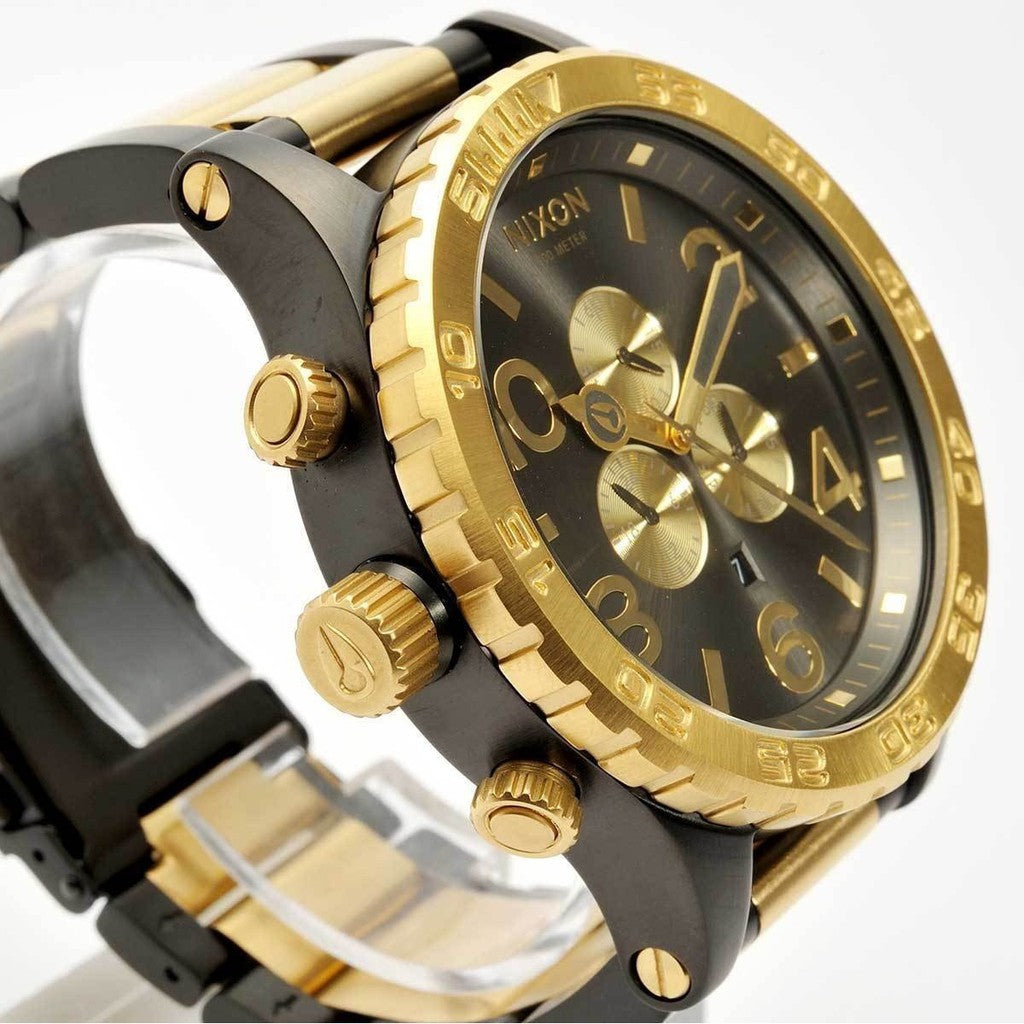 Angled side view of Nixon 51-30 chronograph watch showing gold crown and pushers