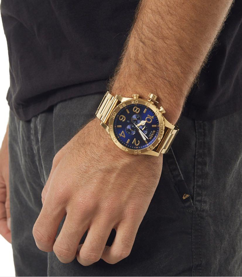 Nixon 51-30 Chrono watch worn on wrist showing blue dial with gold-tone case and bracelet