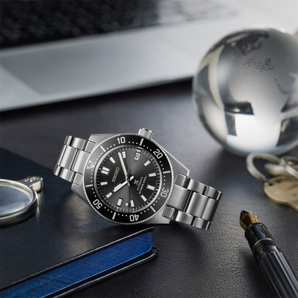 Seiko SPB143J1 silver diver watch displayed on desk with accessories