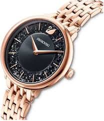 Swarovski Crystalline Chic watch worn on wrist, displaying black dial and rose gold link bracelet
