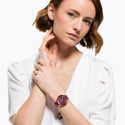 Swarovski gold chronograph watch worn on wrist with burgundy dial and leather band