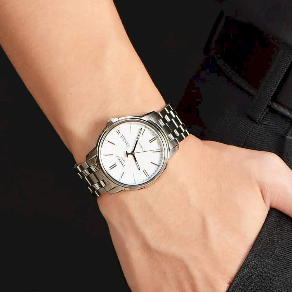 Tissot Automatics III automatic watch worn on wrist with white dial and steel bracelet