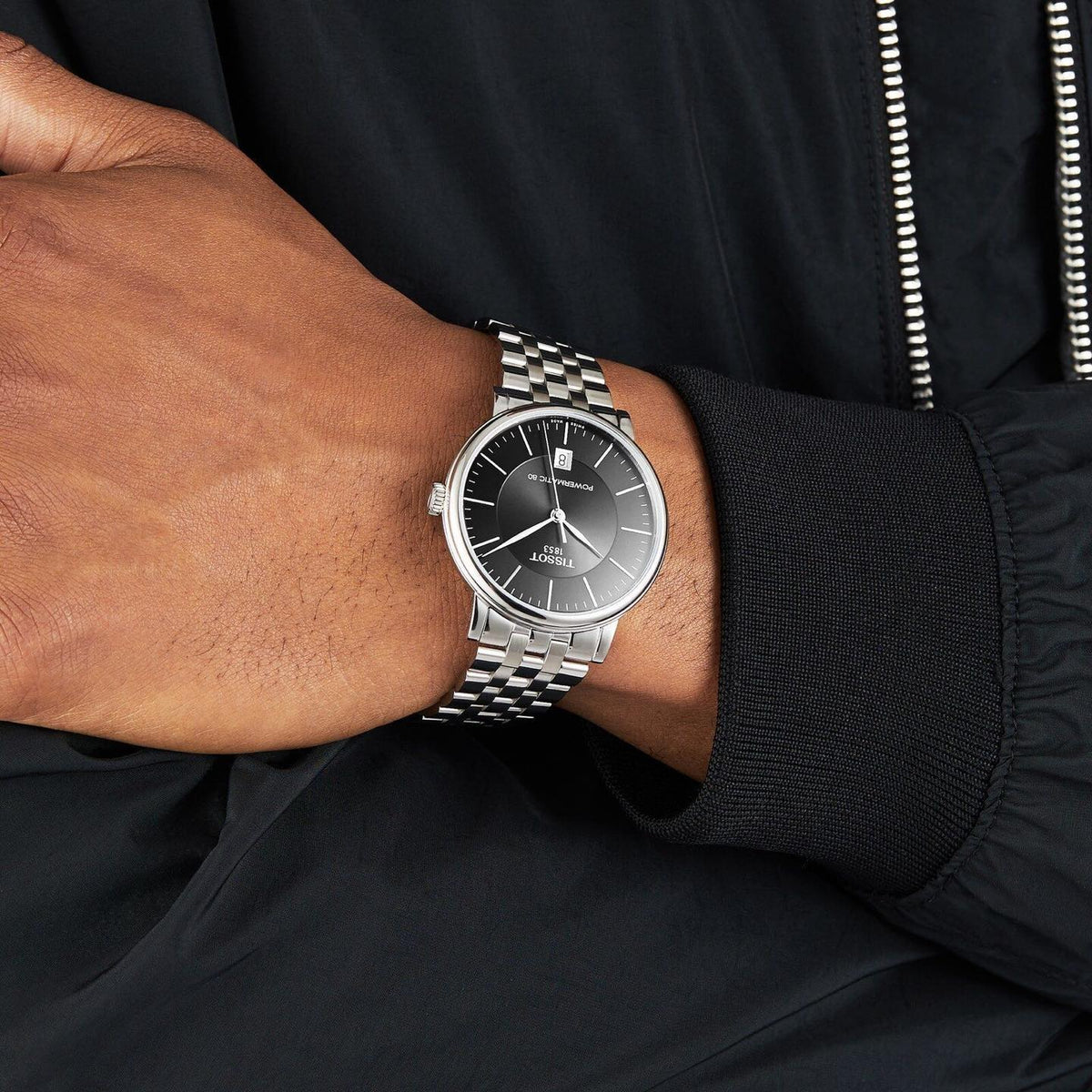 Tissot Carson watch worn on wrist showing black dial with silver steel bracelet