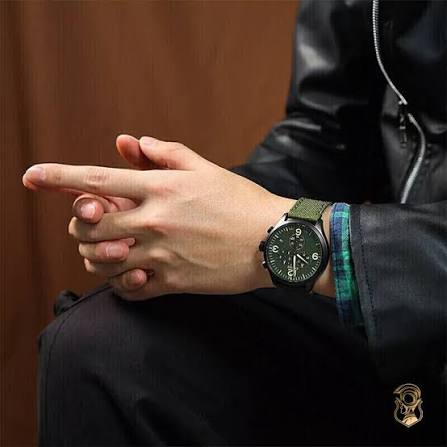 Tissot Chrono XL green dial watch worn on wrist with green and blue striped strap