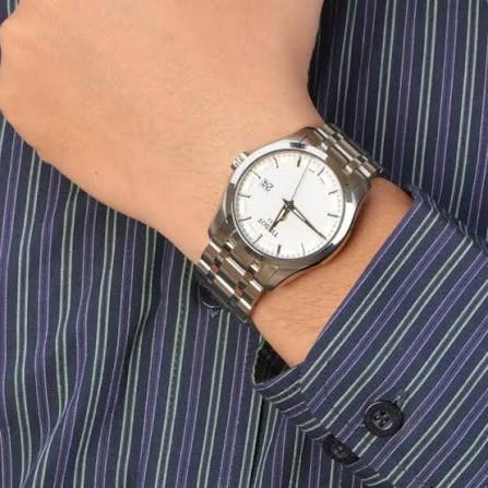 Tissot Couturier worn on wrist with white dial and metal bracelet visible