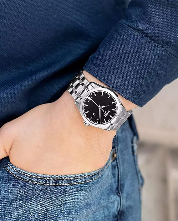 Tissot Couturier watch worn on wrist showing black dial and stainless steel bracelet