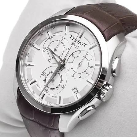 Angled view of Tissot Couturier chronograph watch with silver dial and brown strap