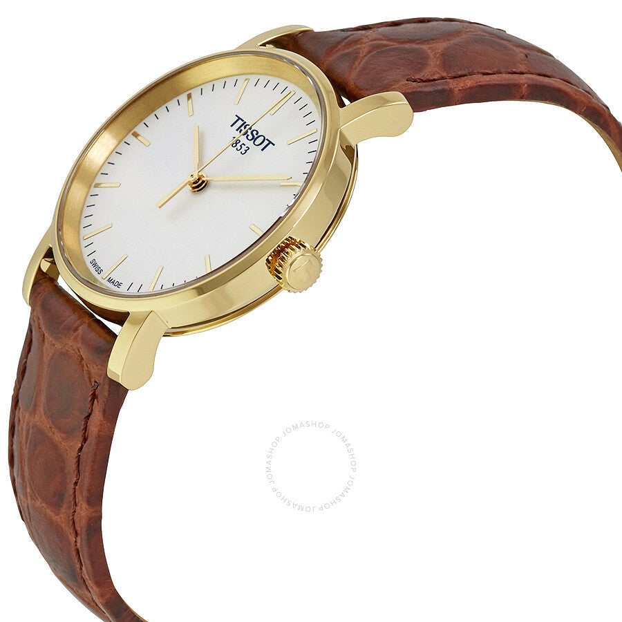 Tissot Everytime watch from angle showing white dial, gold bezel, and brown leather band
