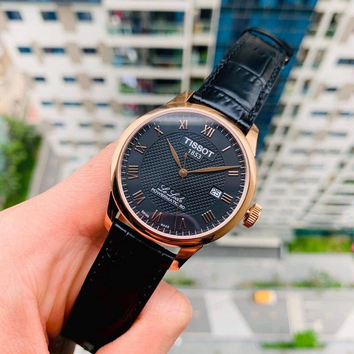 Tissot Le Locle Powermatic 80 rose gold watch in hand with urban background