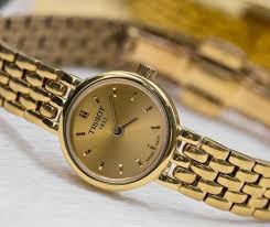 Tissot Lovely watch angled view showing golden dial and yellow gold PVD steel bracelet