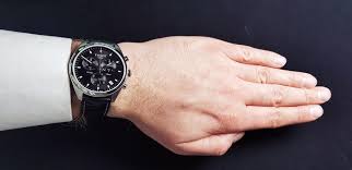 Tissot PR100 chronograph watch worn on wrist with black dial and silver-tone case