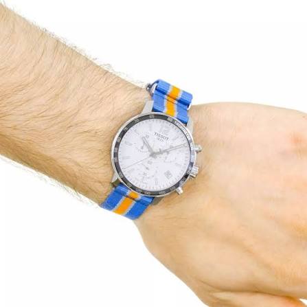 Tissot Quickster Chronograph worn on wrist showing silver case and blue/orange strap