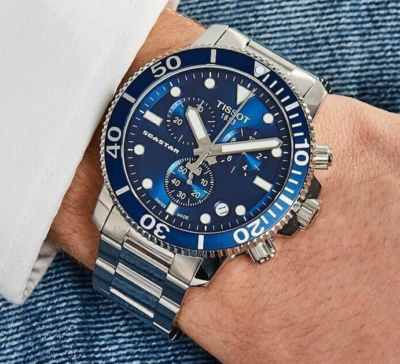 Tissot Seastar 1000 Chronograph blue dial watch worn on wrist with silver steel bracelet