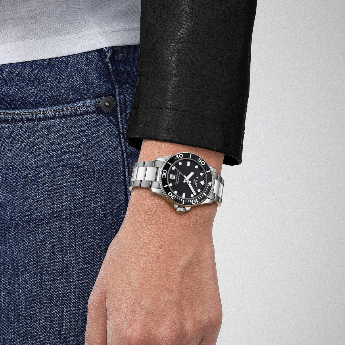 Tissot Seastar 1000 black dial watch worn on wrist with steel bracelet