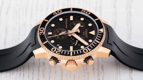 Angled view of Tissot Seastar T-Sport showing rose gold case, chronograph pushers, and black rubber strap