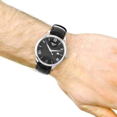 Tissot T-Classic Tradition watch worn on wrist showing black dial and leather strap
