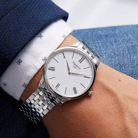 Tissot T Classic Tradition watch worn on wrist with white dial and steel bracelet