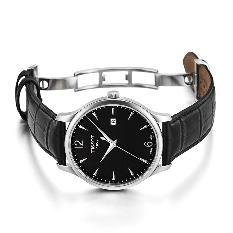 Tissot T Classic Tradition watch worn on wrist with black crocodile leather strap and steel bracelet