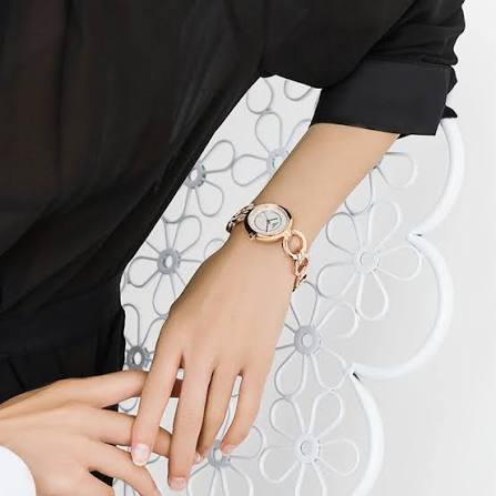 Tissot T-Lady Flamingo rose gold watch worn on wrist with linked bracelet