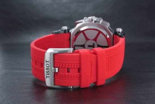 Red rubber strap with Tissot branding and stainless steel buckle