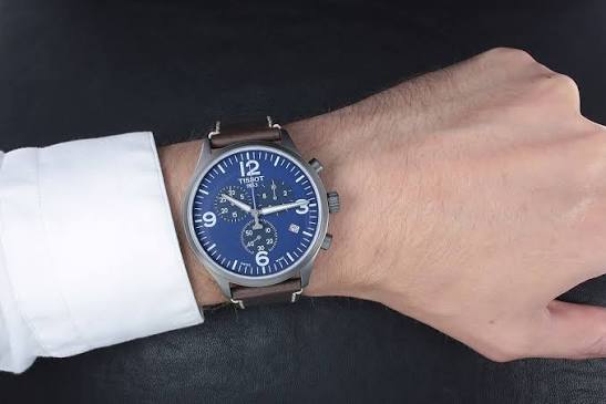 Tissot T-Sport Chronograph XL blue dial chronograph watch worn on wrist with brown leather strap