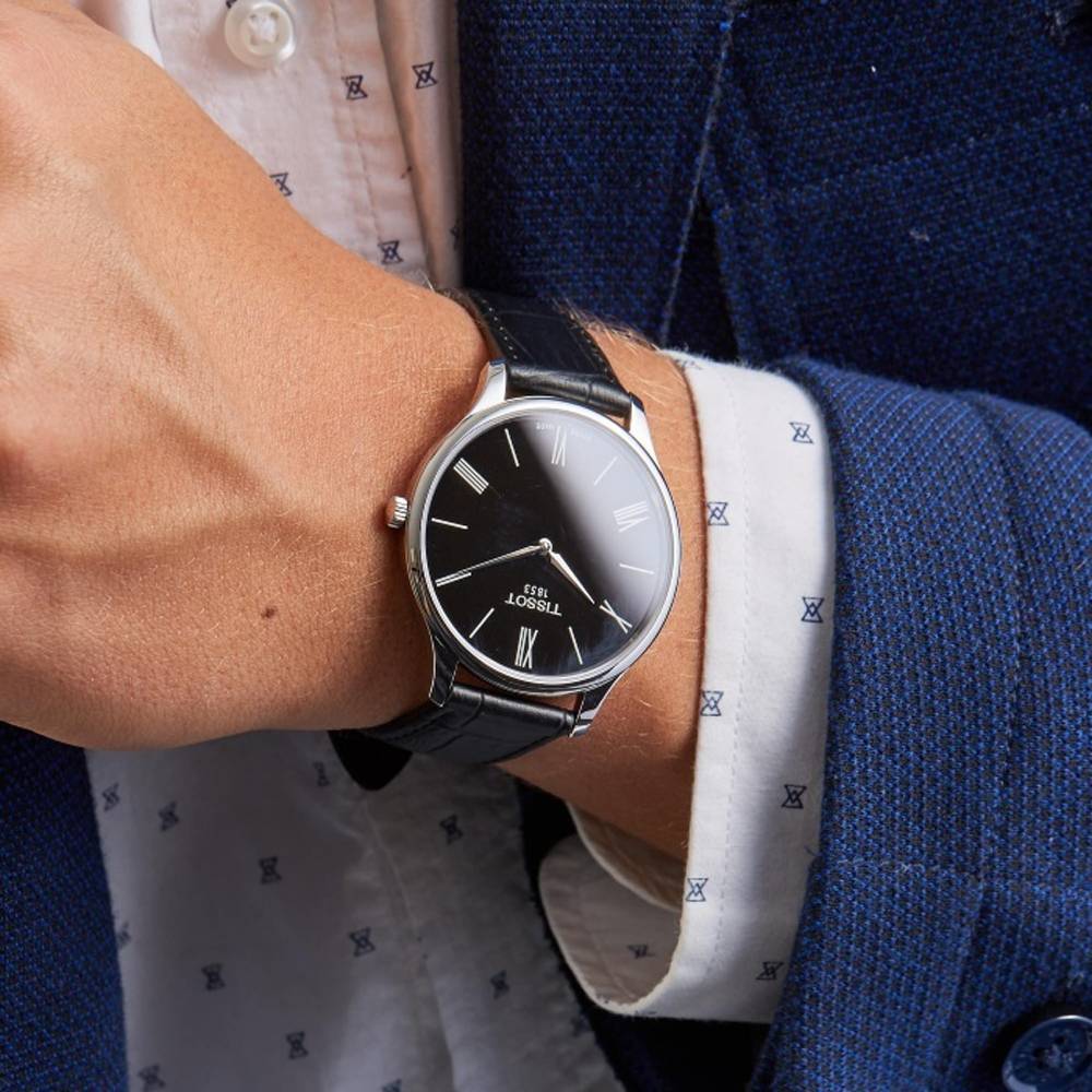 Tissot Tradition 39mm watch worn on wrist with blue jacket and white shirt cuff