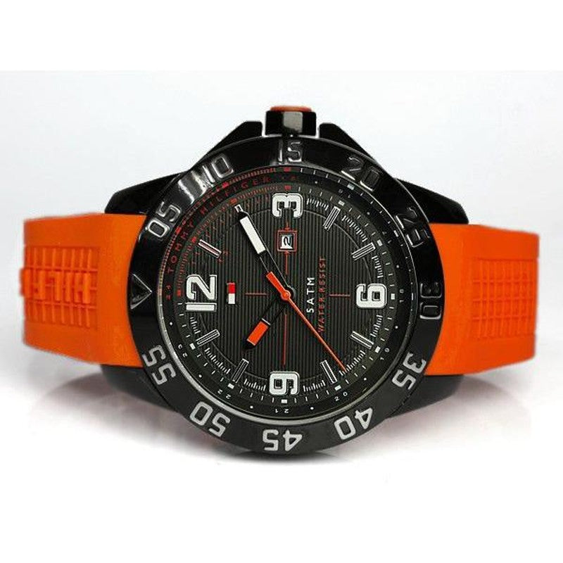 Tommy Hilfiger men's rubber watch with orange strap worn on wrist, black dial and bezel visible