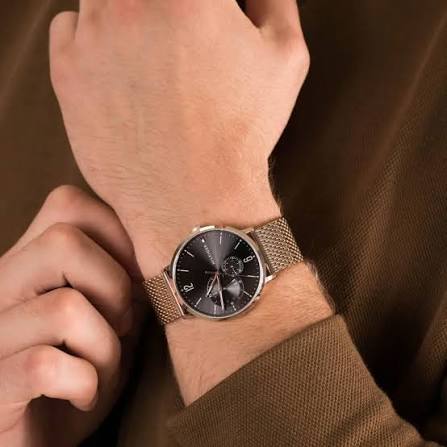 Tommy Hilfiger grey dial watch with rose gold mesh strap worn on wrist