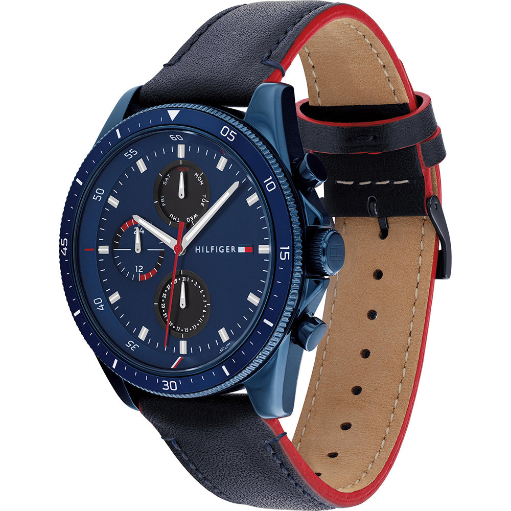 Tommy Hilfiger 1791839 watch at angle showing blue case, navy dial, and black leather strap with red accent