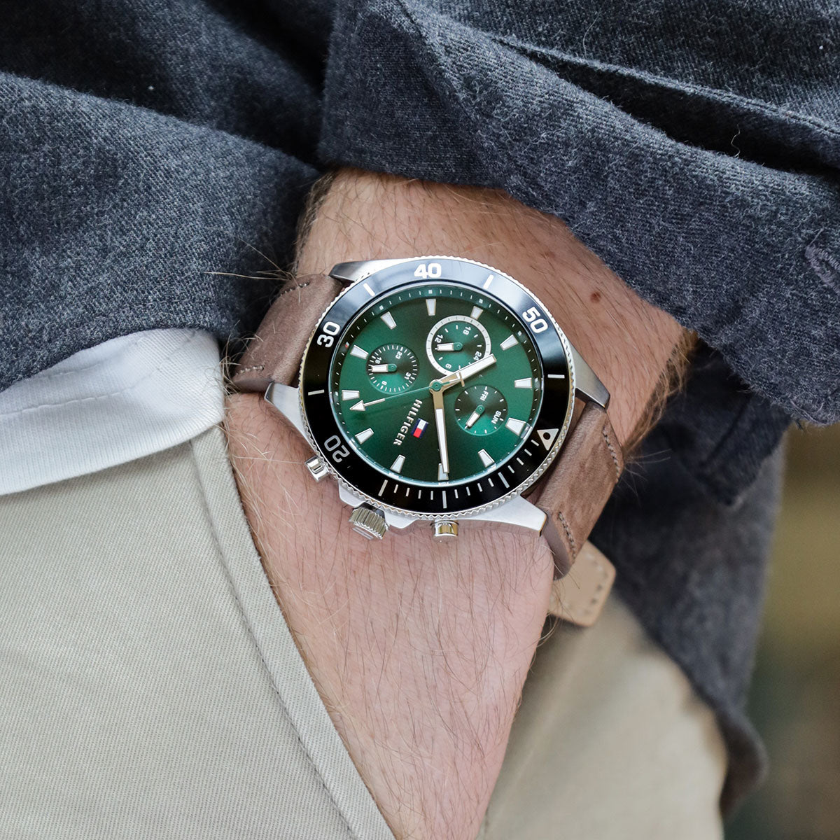 Tommy Hilfiger men's chronograph watch on wrist showing green dial and black bezel