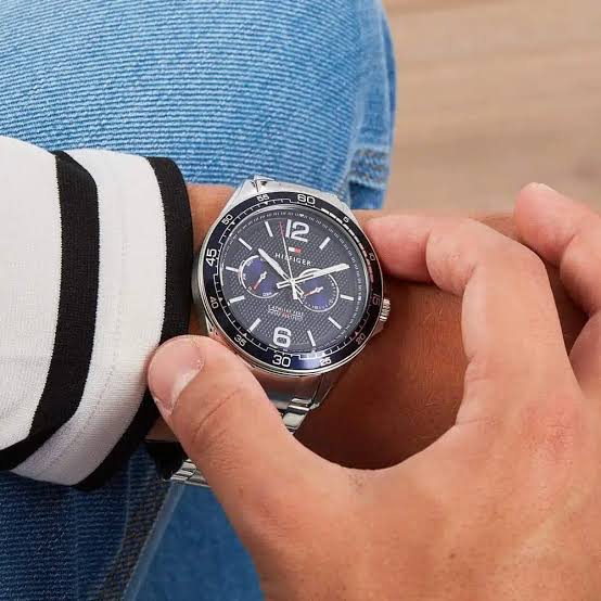Tommy Hilfiger Erik watch worn on wrist with striped sleeve