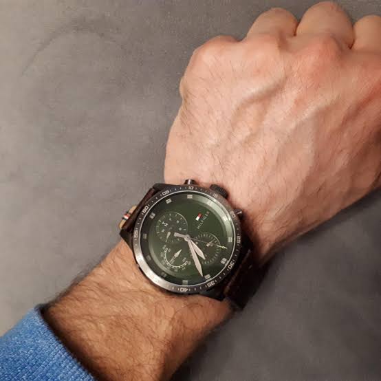 Tommy Hilfiger Trent watch worn on wrist showing green chronograph dial and brown leather strap