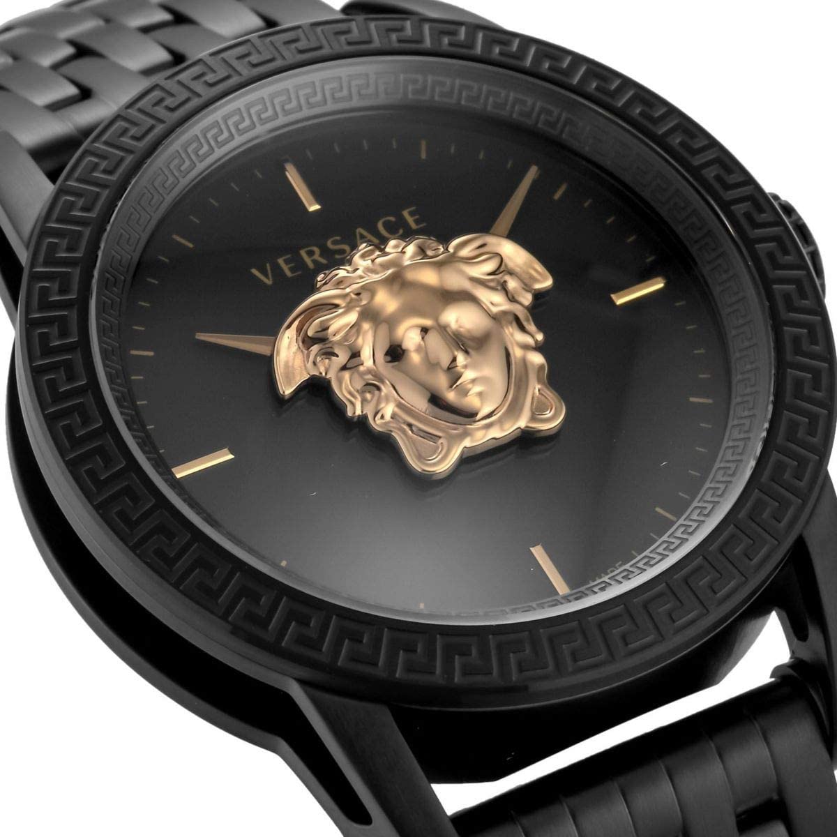 Close-up of black dial with gold Medusa medallion and rose gold hour markers
