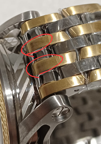 Bracelet link detail showing alternating gold and silver tone metal with highlighted defect areas