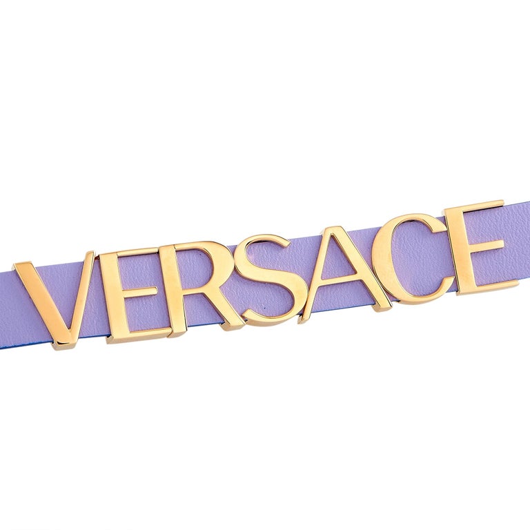Versace V-Flare watch strap close-up showing purple leather band with large gold VERSACE lettering