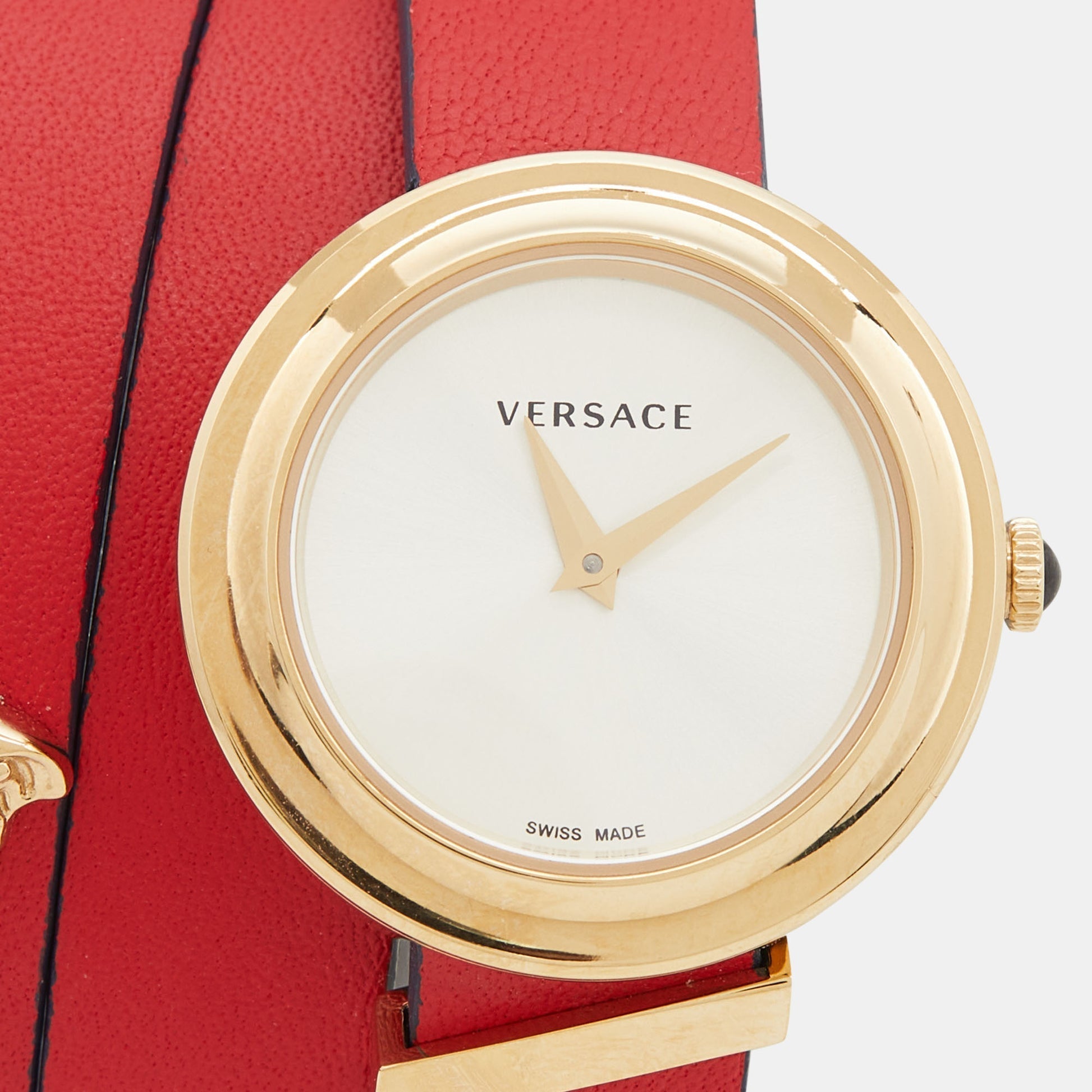 Close-up of silver dial with gold hands and Versace branding, Swiss made marking visible