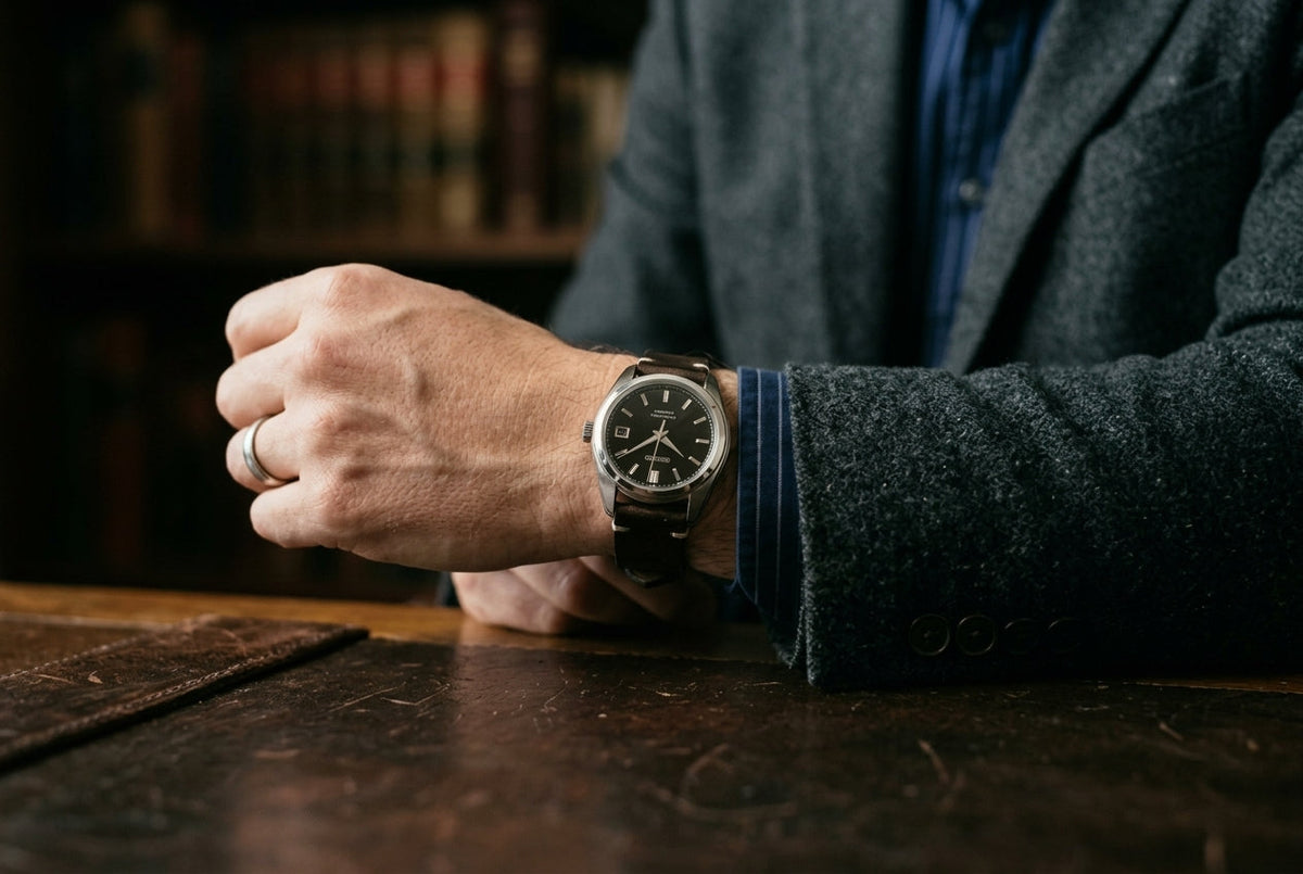 A man showcasing a stylish watch on his wrist, highlighting its design and elegance.